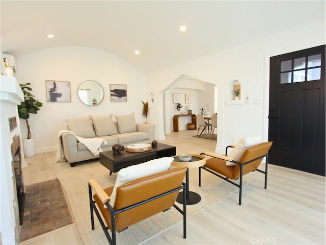 living room with light hardwood / wood-style floors and vaulted ceiling