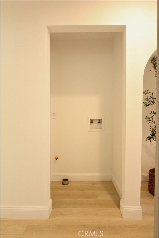 clothes washing area featuring wood-type flooring and hookup for a washing machine