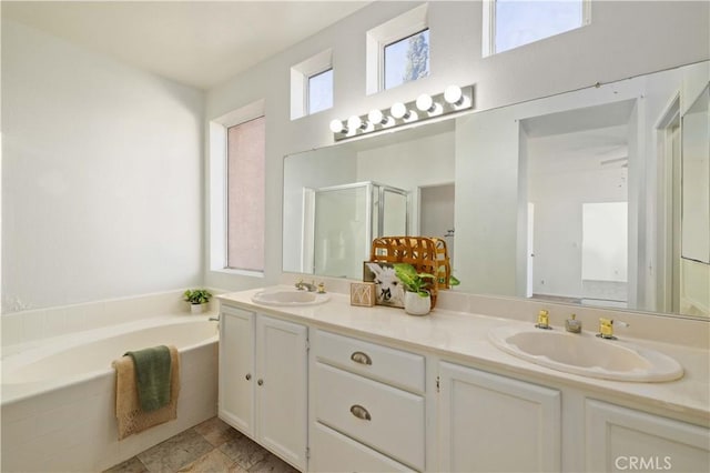 bathroom featuring vanity and independent shower and bath