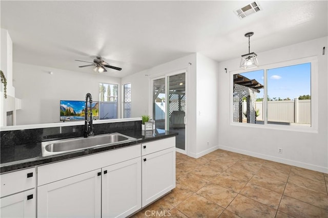 kitchen with white cabinets, decorative light fixtures, ceiling fan, and sink