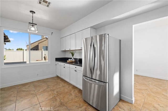 kitchen featuring stainless steel fridge, white cabinets, pendant lighting, and light tile patterned floors