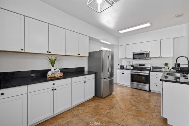 kitchen with light tile patterned floors, white cabinetry, sink, and appliances with stainless steel finishes