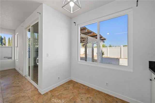 unfurnished dining area featuring light tile patterned floors and a wealth of natural light