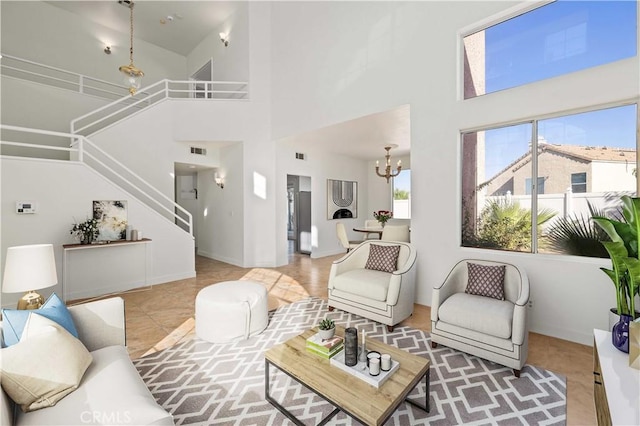 tiled living room featuring a towering ceiling and a chandelier