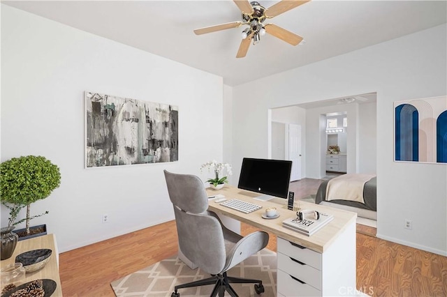 home office with ceiling fan and light hardwood / wood-style flooring