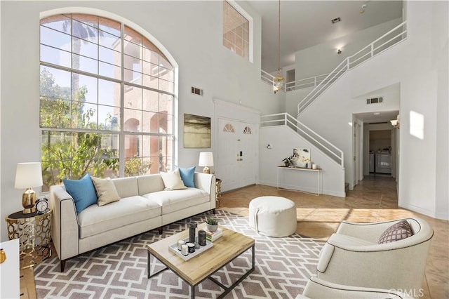 living room featuring plenty of natural light, washer / dryer, and a towering ceiling