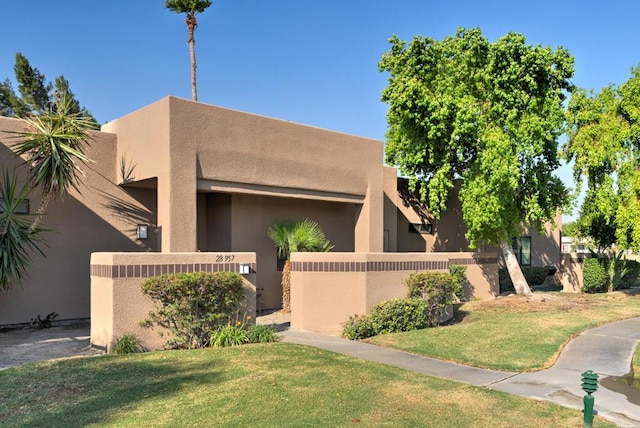 pueblo-style home with a front lawn