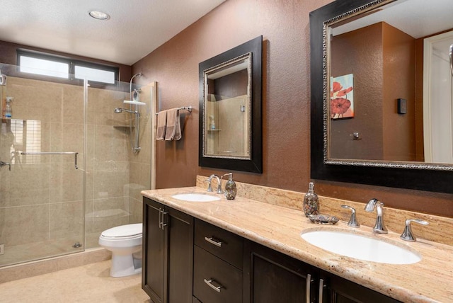 bathroom with vanity, toilet, and a shower with door