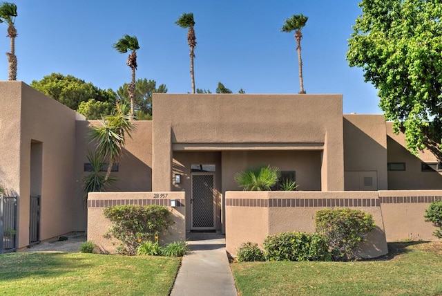 pueblo revival-style home featuring a front yard