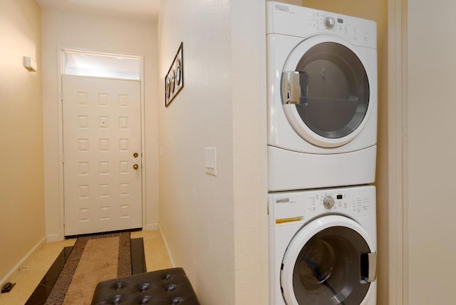 washroom with tile patterned flooring and stacked washing maching and dryer