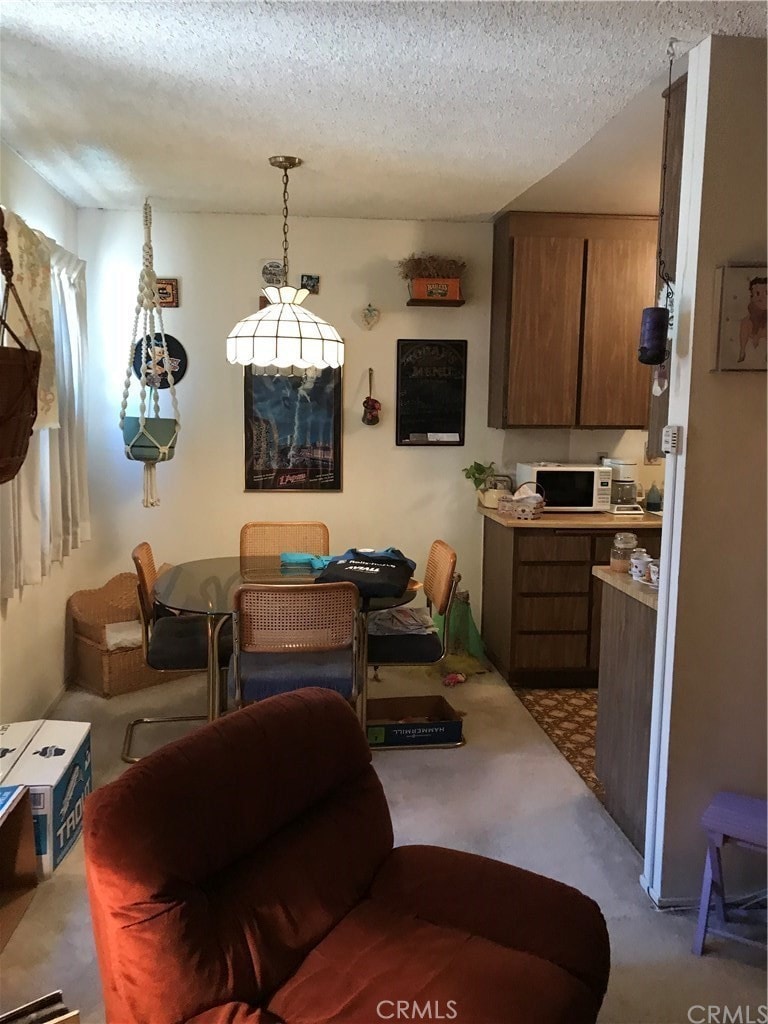 carpeted living room featuring a textured ceiling