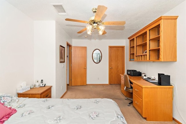 carpeted bedroom featuring ceiling fan and a textured ceiling