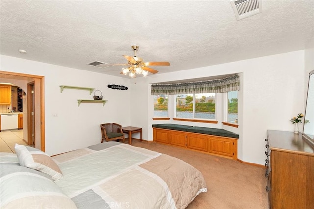 bedroom featuring ceiling fan, light colored carpet, and a textured ceiling