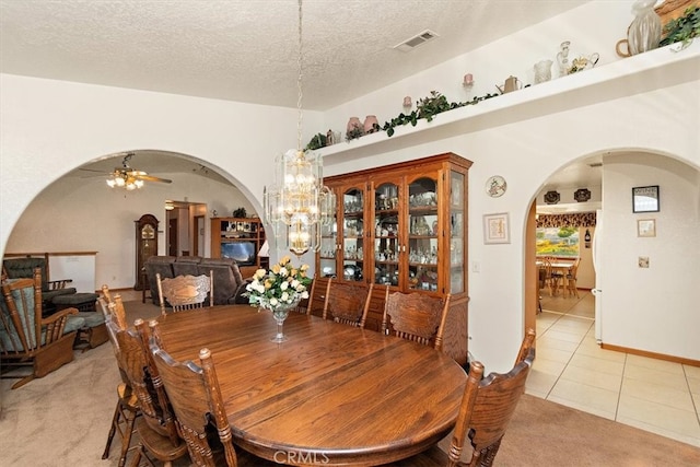 dining room featuring a textured ceiling, ceiling fan with notable chandelier, and light tile patterned floors