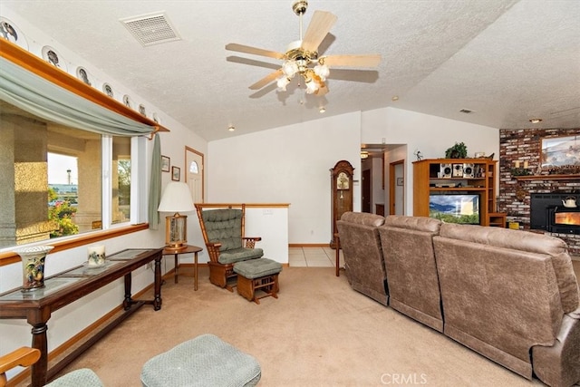 carpeted living room with a brick fireplace, lofted ceiling, ceiling fan, and a textured ceiling