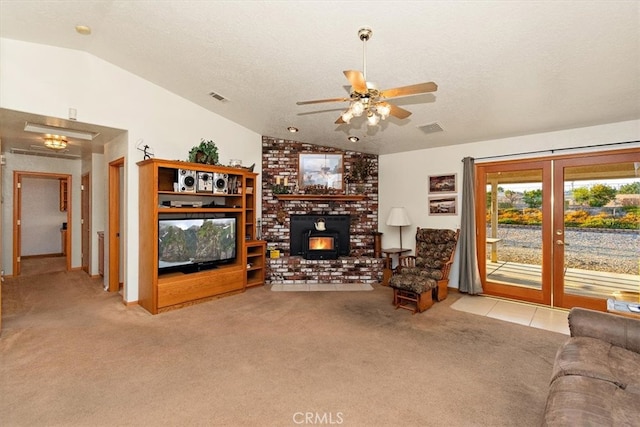 carpeted living room with a brick fireplace, lofted ceiling, ceiling fan, and a textured ceiling