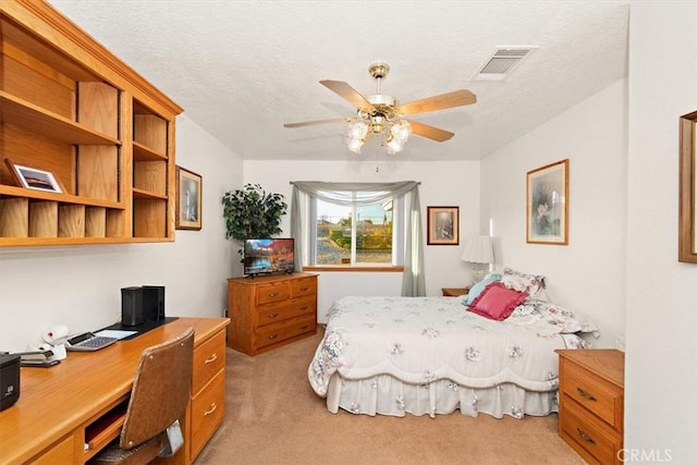 bedroom featuring visible vents, ceiling fan, light colored carpet, and a textured ceiling