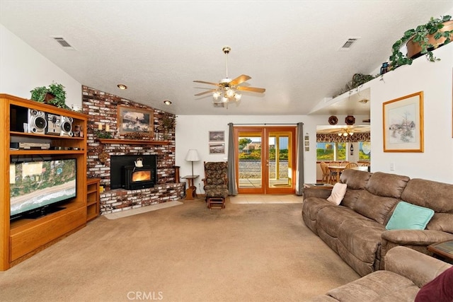 living room with ceiling fan, a brick fireplace, a textured ceiling, light colored carpet, and vaulted ceiling