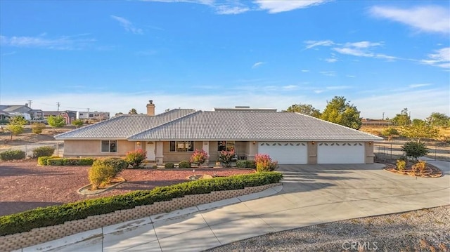 ranch-style house featuring a tiled roof, a garage, stucco siding, a chimney, and driveway