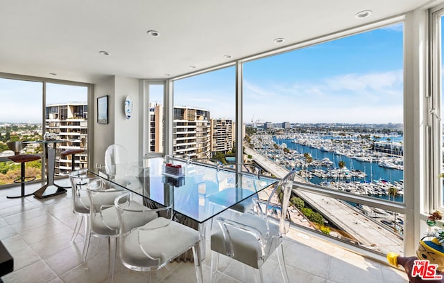 dining room with expansive windows and a water view