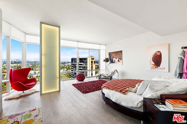 bedroom with hardwood / wood-style floors and a wall of windows