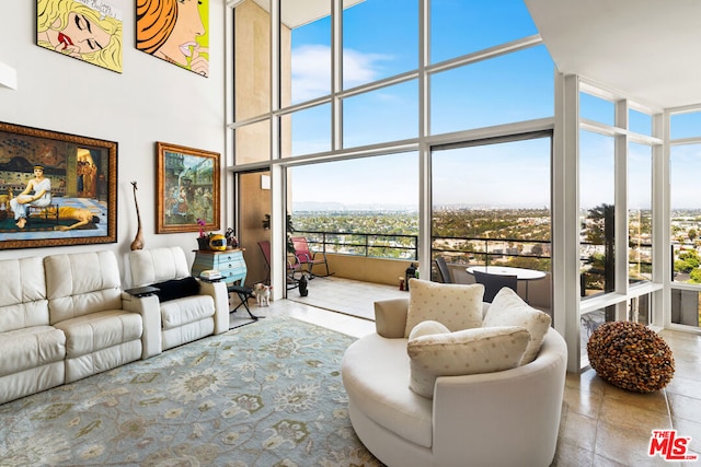 living room featuring a towering ceiling and floor to ceiling windows