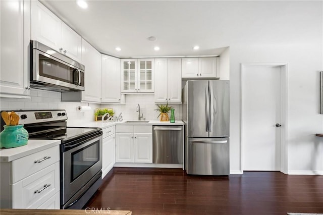 kitchen featuring white cabinets, stainless steel appliances, and dark wood-type flooring