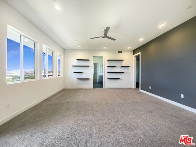 unfurnished living room with carpet and ceiling fan