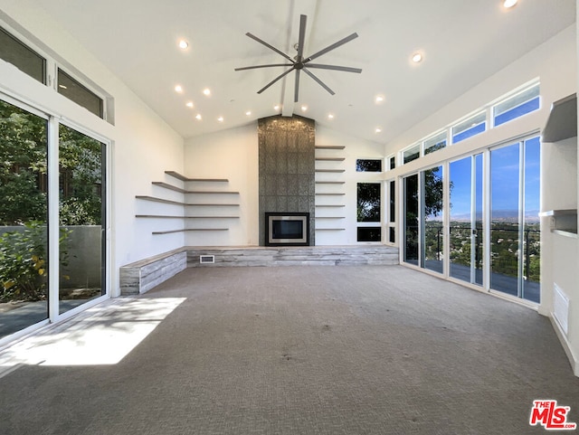 unfurnished living room with carpet, plenty of natural light, and a fireplace