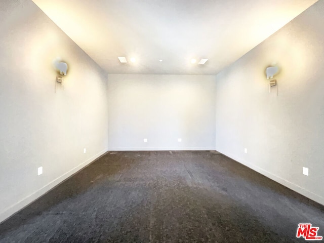 unfurnished room with dark colored carpet