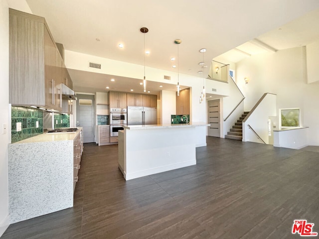 kitchen with light stone countertops, a center island, stainless steel appliances, dark hardwood / wood-style floors, and pendant lighting