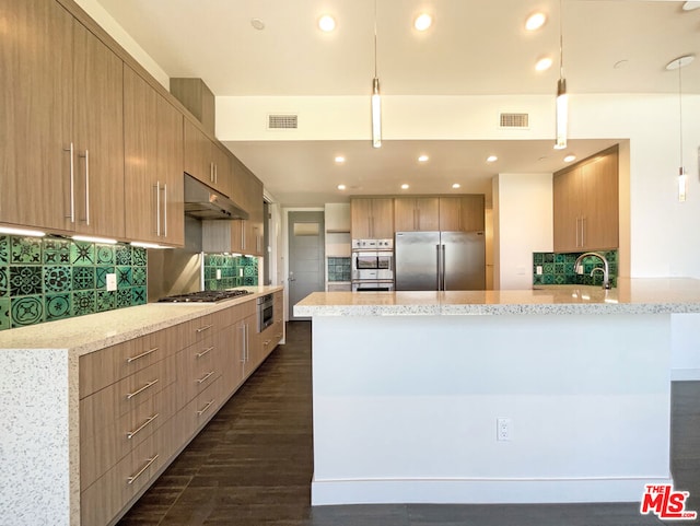 kitchen featuring pendant lighting, dark hardwood / wood-style flooring, light stone countertops, and appliances with stainless steel finishes