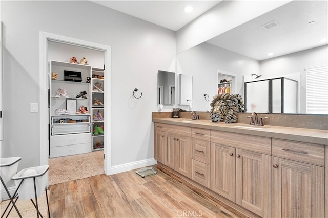 bathroom featuring walk in shower, vanity, and hardwood / wood-style floors