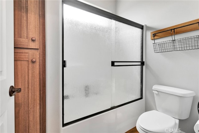 bathroom with shower / bath combination with glass door and toilet