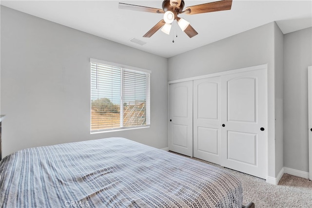 bedroom with ceiling fan, light colored carpet, and a closet