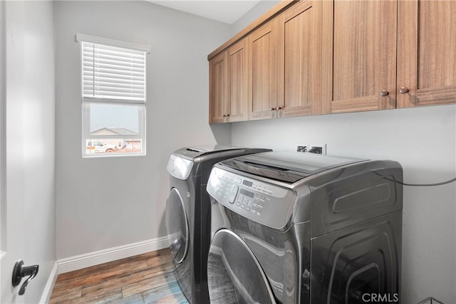 laundry area featuring cabinets, dark hardwood / wood-style floors, and separate washer and dryer