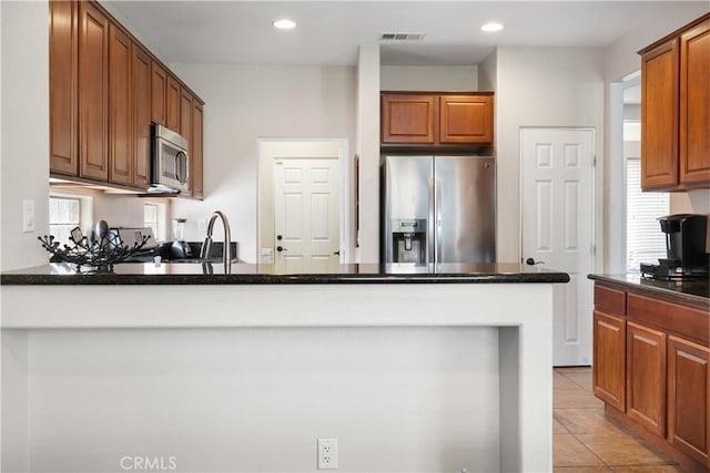 kitchen featuring appliances with stainless steel finishes, light tile patterned floors, a healthy amount of sunlight, and sink