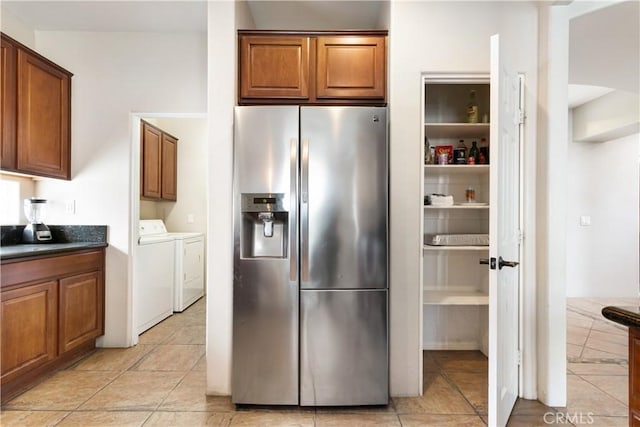 kitchen with washing machine and dryer, light tile patterned floors, and stainless steel refrigerator with ice dispenser