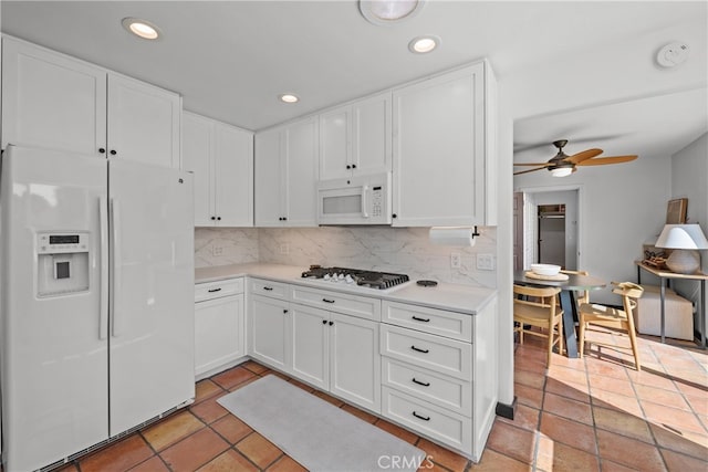 kitchen featuring ceiling fan, white cabinets, backsplash, and white appliances