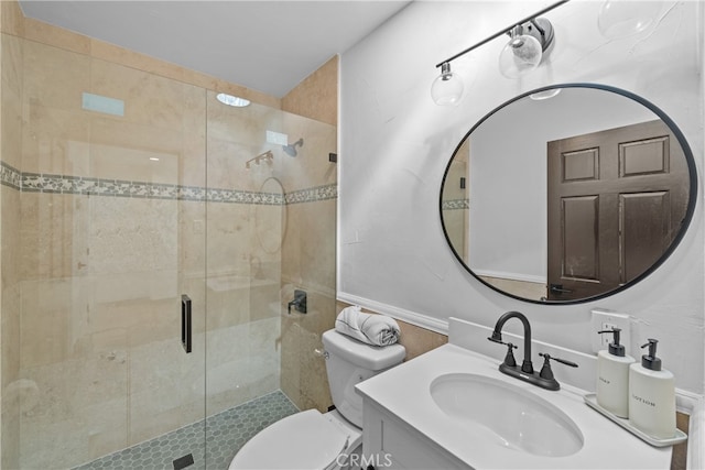 bathroom with vanity, a shower with shower door, and toilet