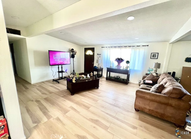 living room featuring light hardwood / wood-style floors, lofted ceiling, and a textured ceiling