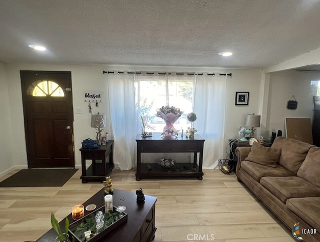 living room with a textured ceiling and light wood-type flooring