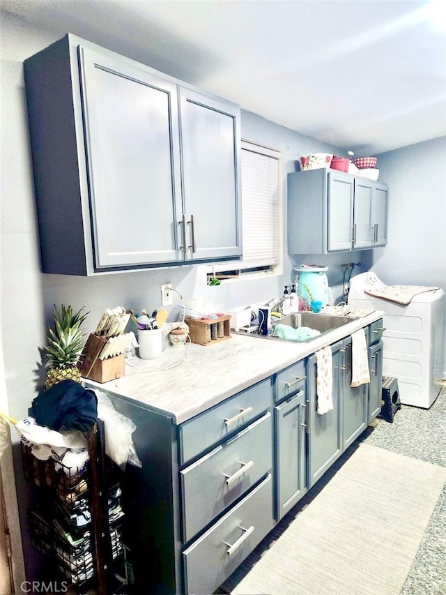 kitchen with carpet, washer / dryer, and sink