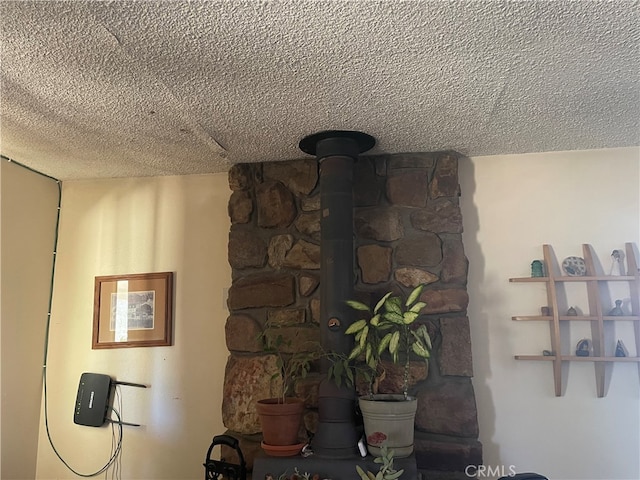 interior details with a textured ceiling and a wood stove