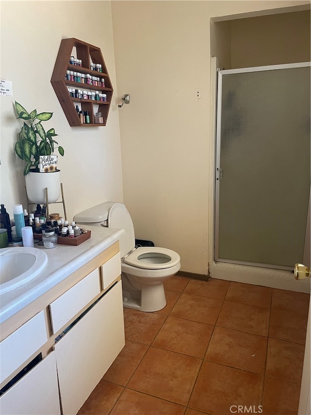 bathroom featuring vanity, toilet, tile patterned floors, and a shower with door