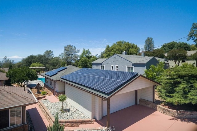 view of front facade featuring a garage and solar panels