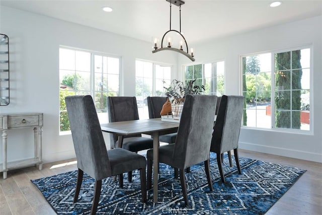 dining area with a notable chandelier, hardwood / wood-style floors, and a healthy amount of sunlight