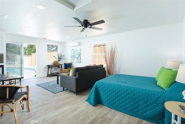 bedroom with access to outside, light hardwood / wood-style floors, an AC wall unit, and ceiling fan