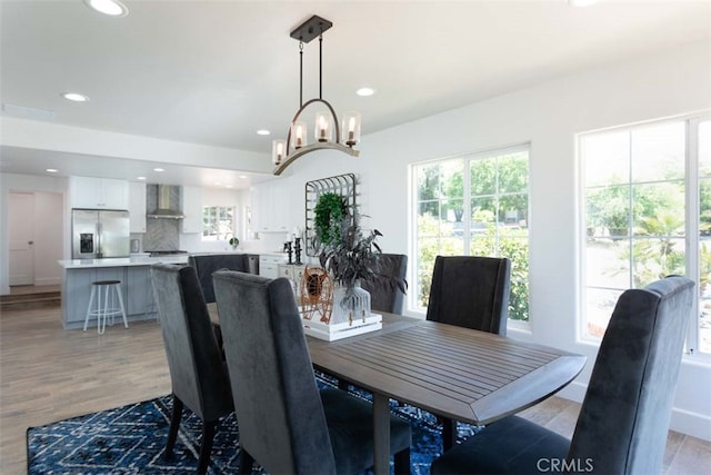 dining room with light hardwood / wood-style flooring and a notable chandelier