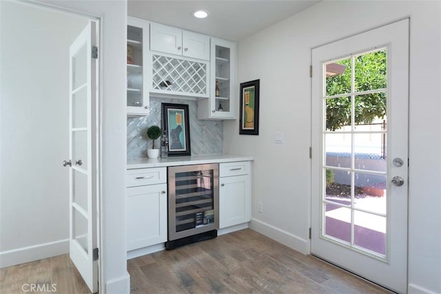 bar featuring beverage cooler, dark wood-type flooring, and white cabinetry